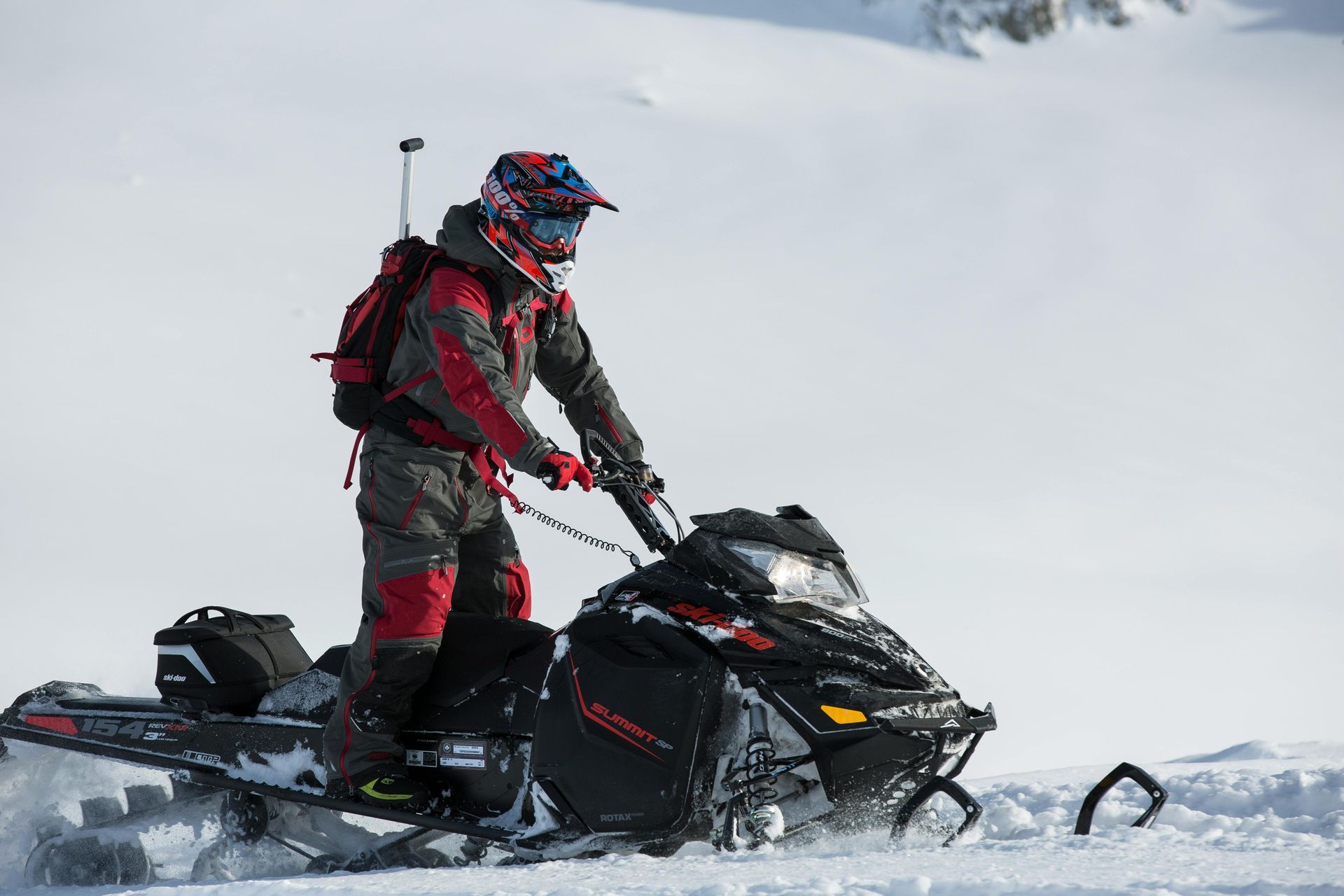 A man is riding a snowmobile in the snow.