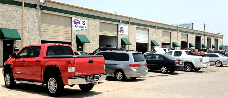 A red truck is parked in front of a building.