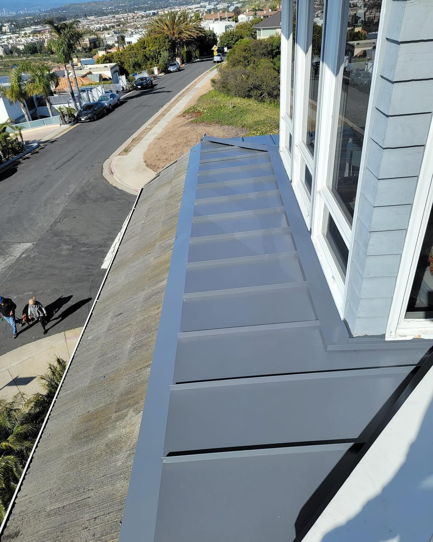 An aerial view of a building with a balcony overlooking a street