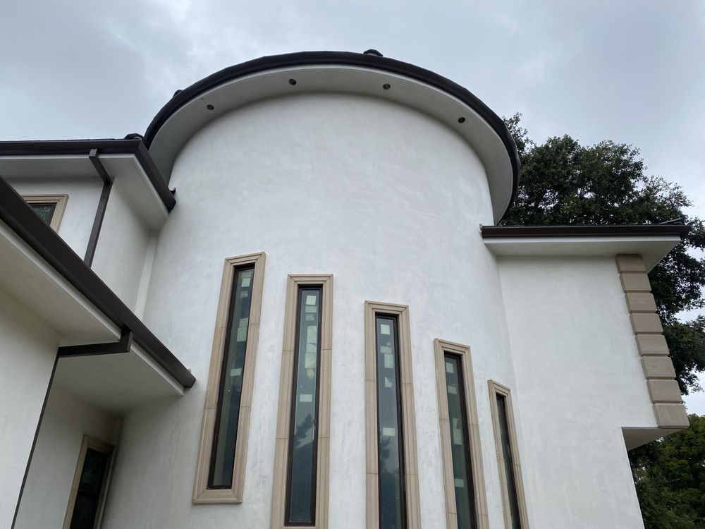 A white building with a curved roof and a lot of windows