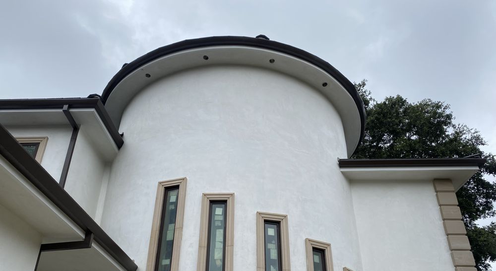 A white building with a curved roof and a lot of windows