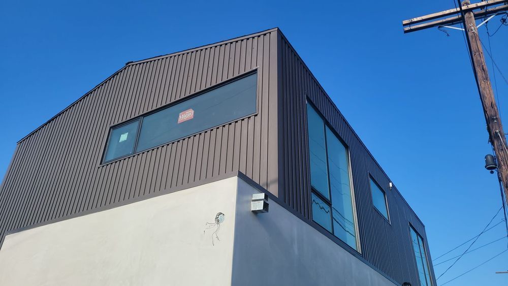 A large building with a lot of windows and a blue sky in the background.