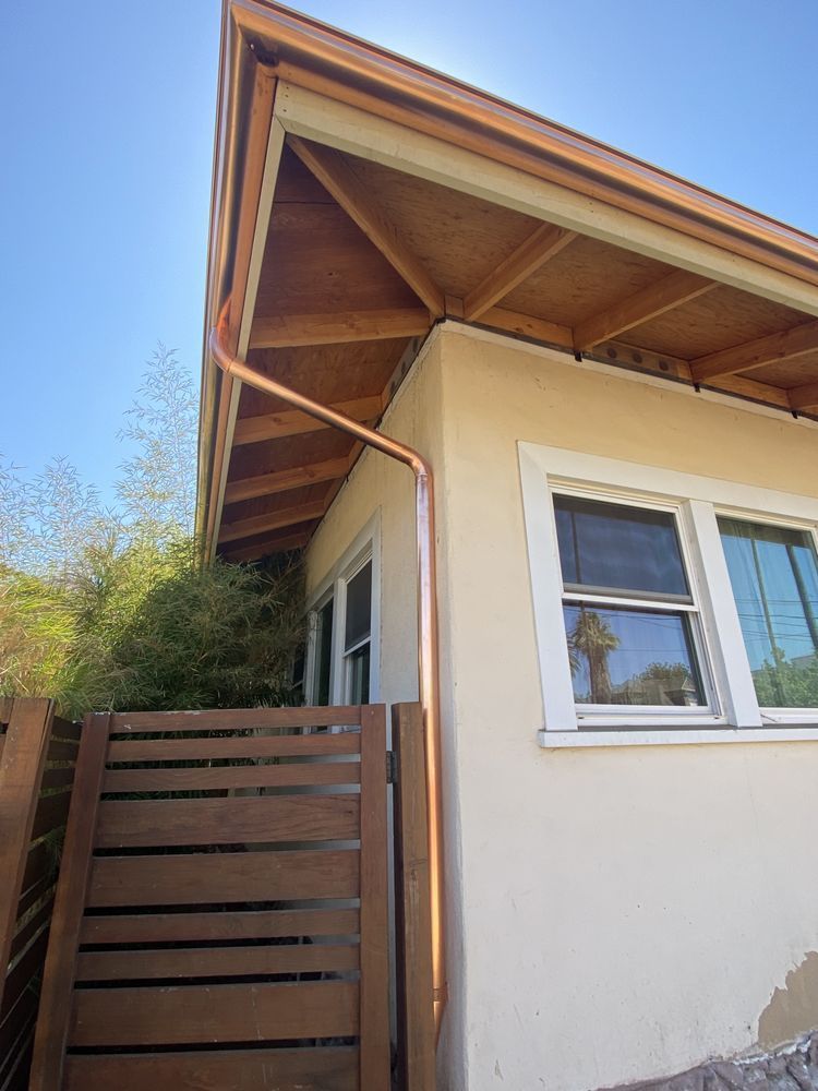 A house with a copper gutter on the side of it