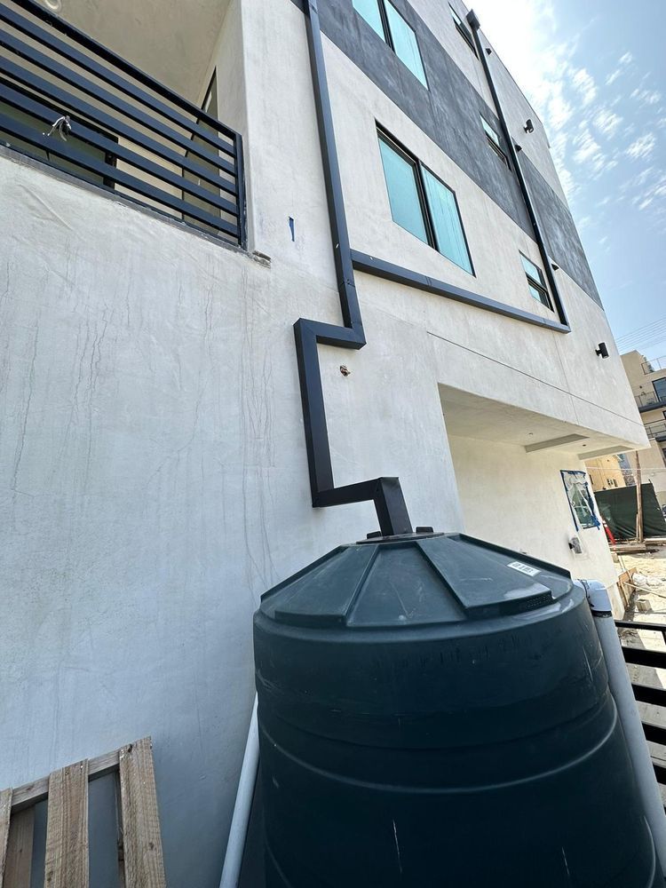 A large black tank is sitting on the side of a building.