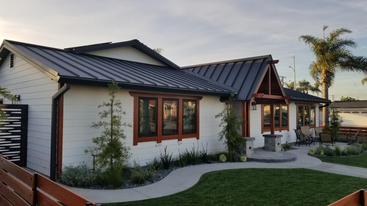 A green metal roof is being installed on a house.