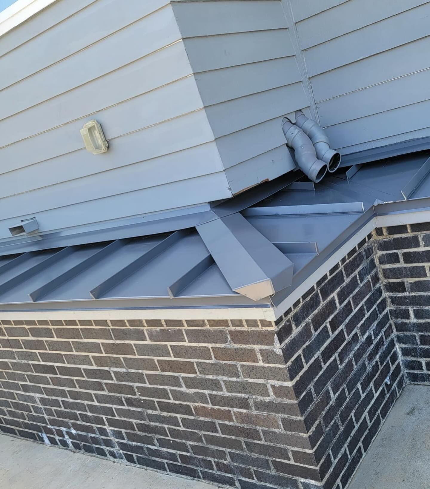 A building with a metal roof and a brick wall