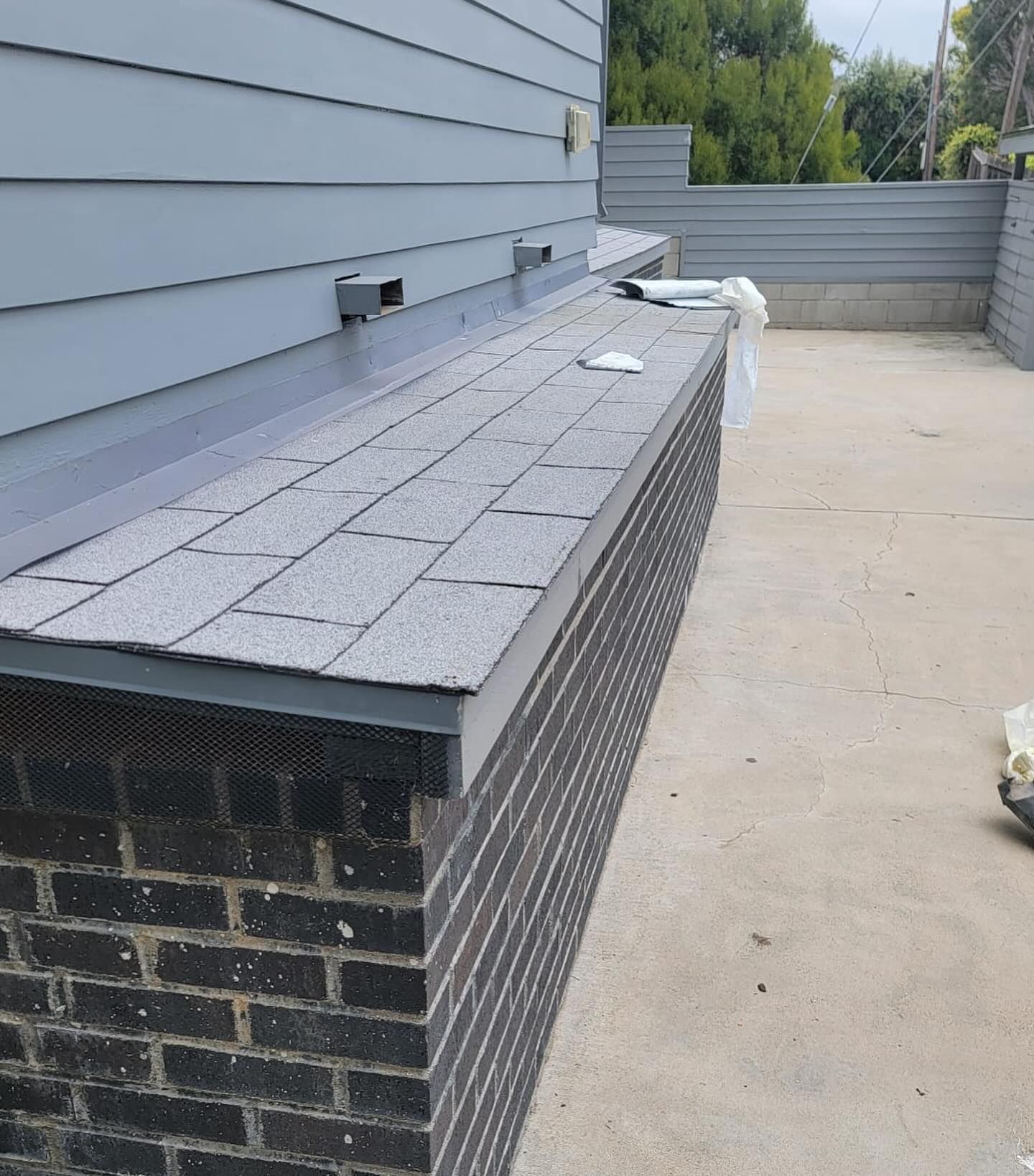 A brick wall with shingles on top of it