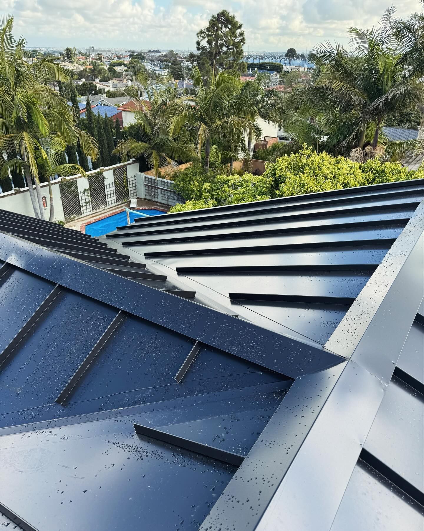 A close up of a roof with a pool in the background.