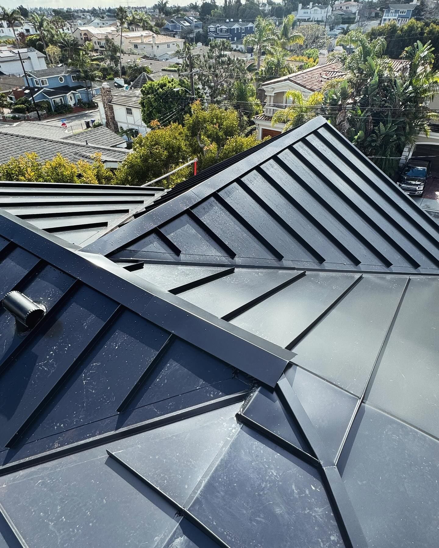 A close up of a black roof with a city in the background