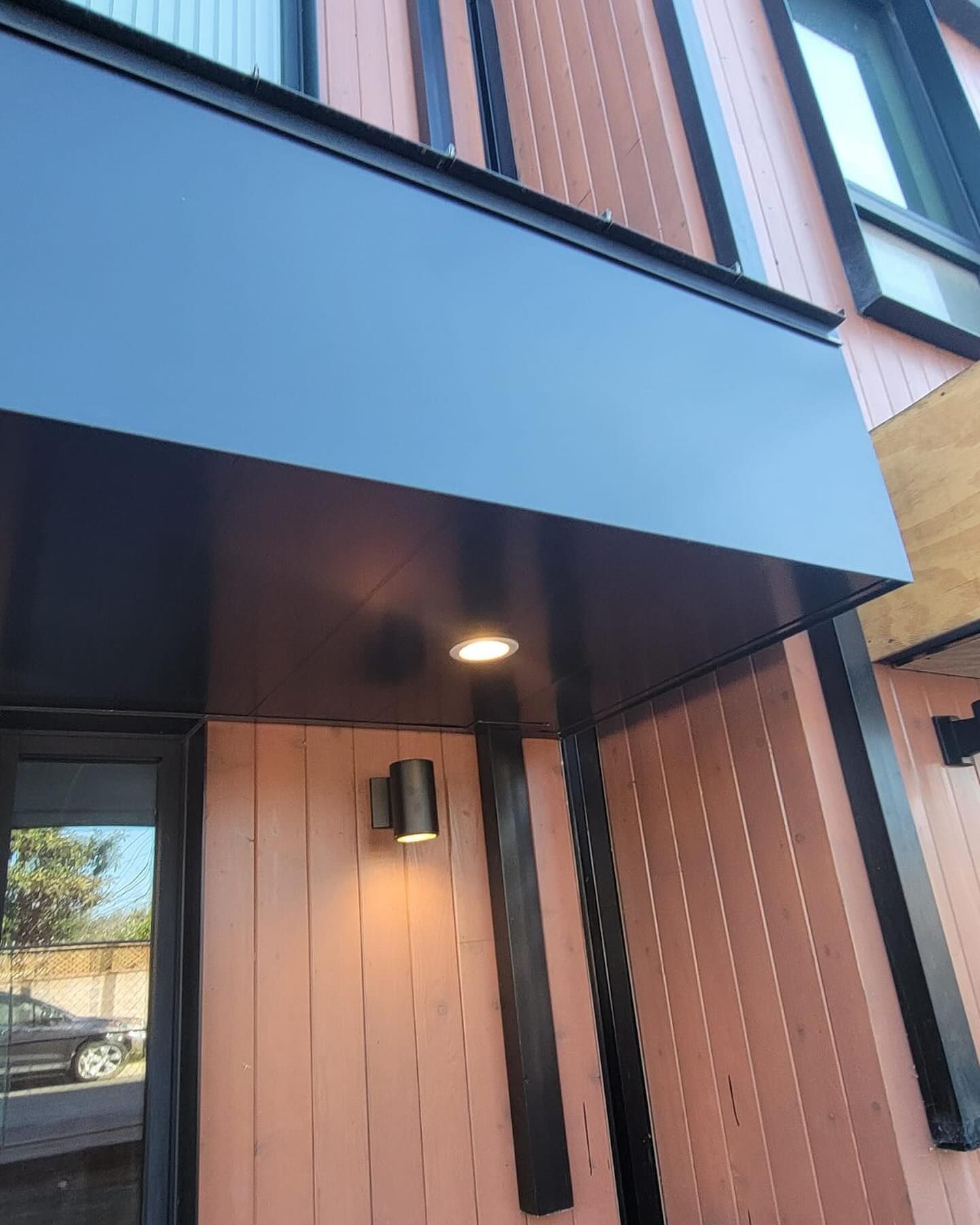 A building with a black awning over the front door