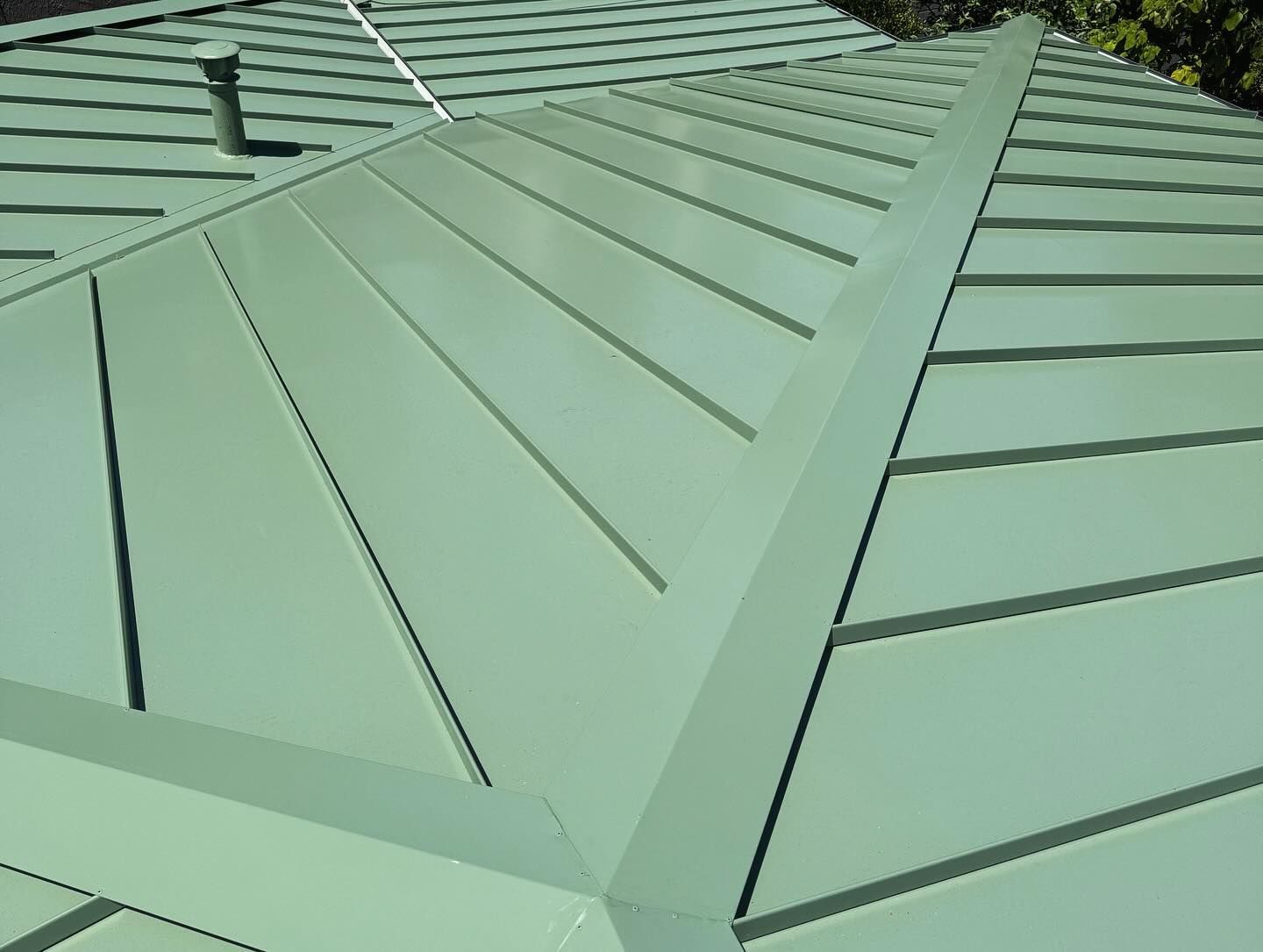 A close up of a green metal roof on a house.