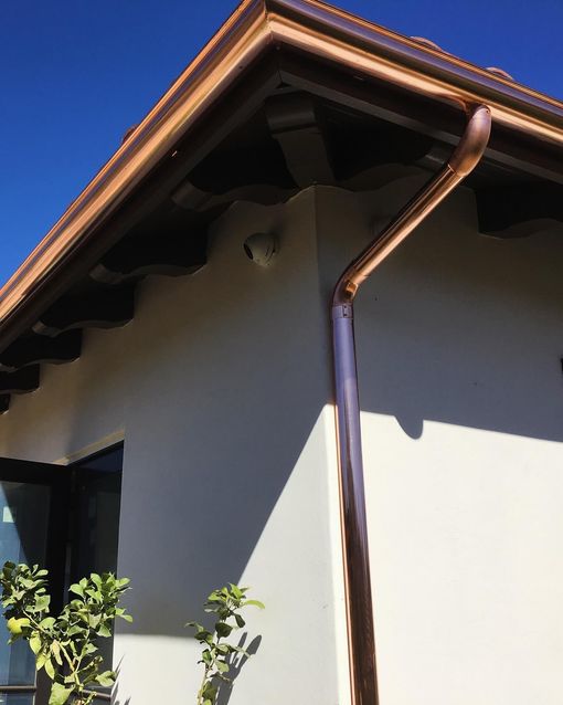 A copper gutter on the side of a house