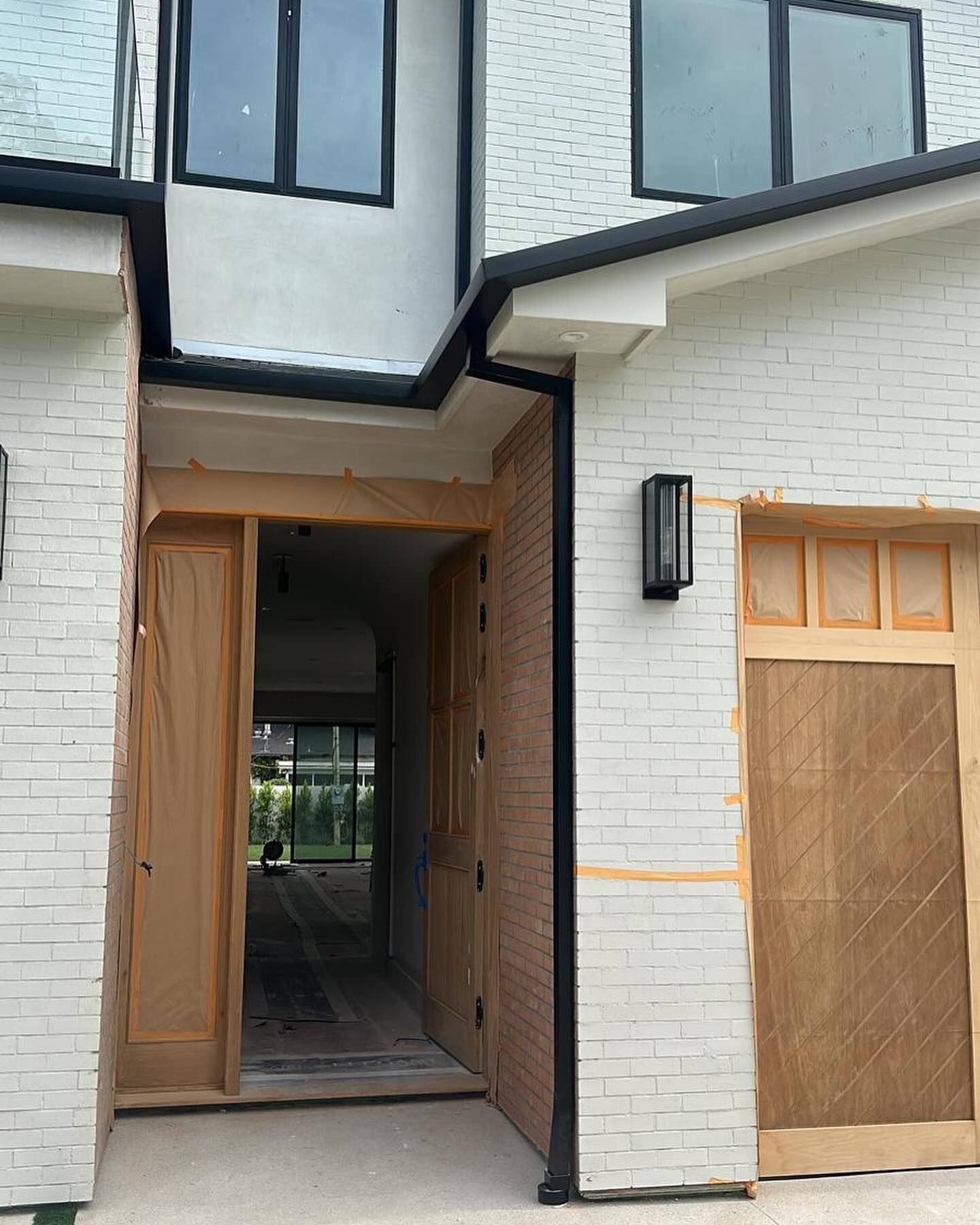 A white brick house with a wooden garage door