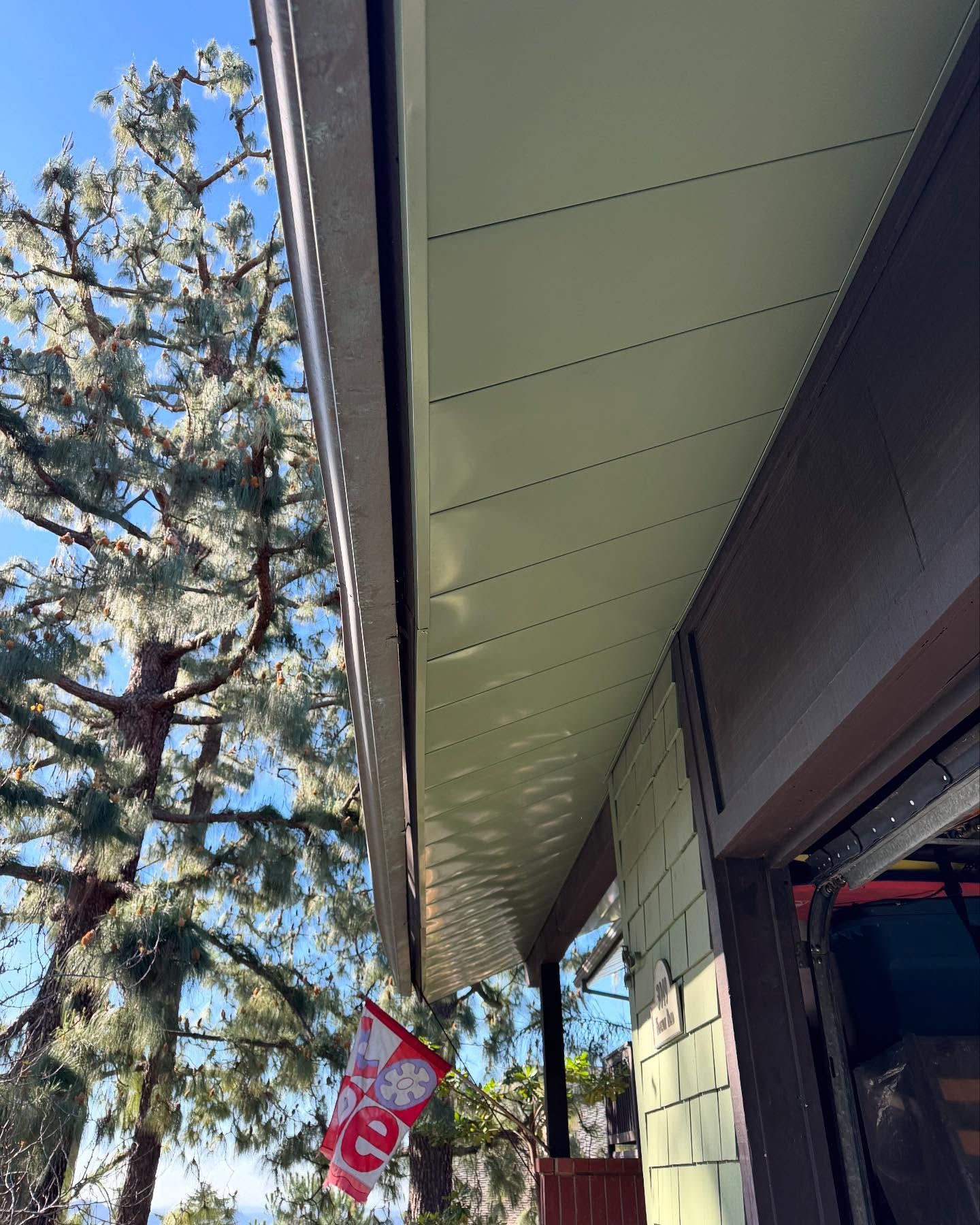 A red and white flag is hanging from the roof of a house.