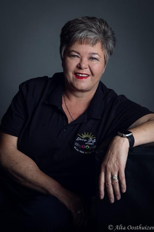 A woman wearing a black shirt and a watch is smiling for the camera.