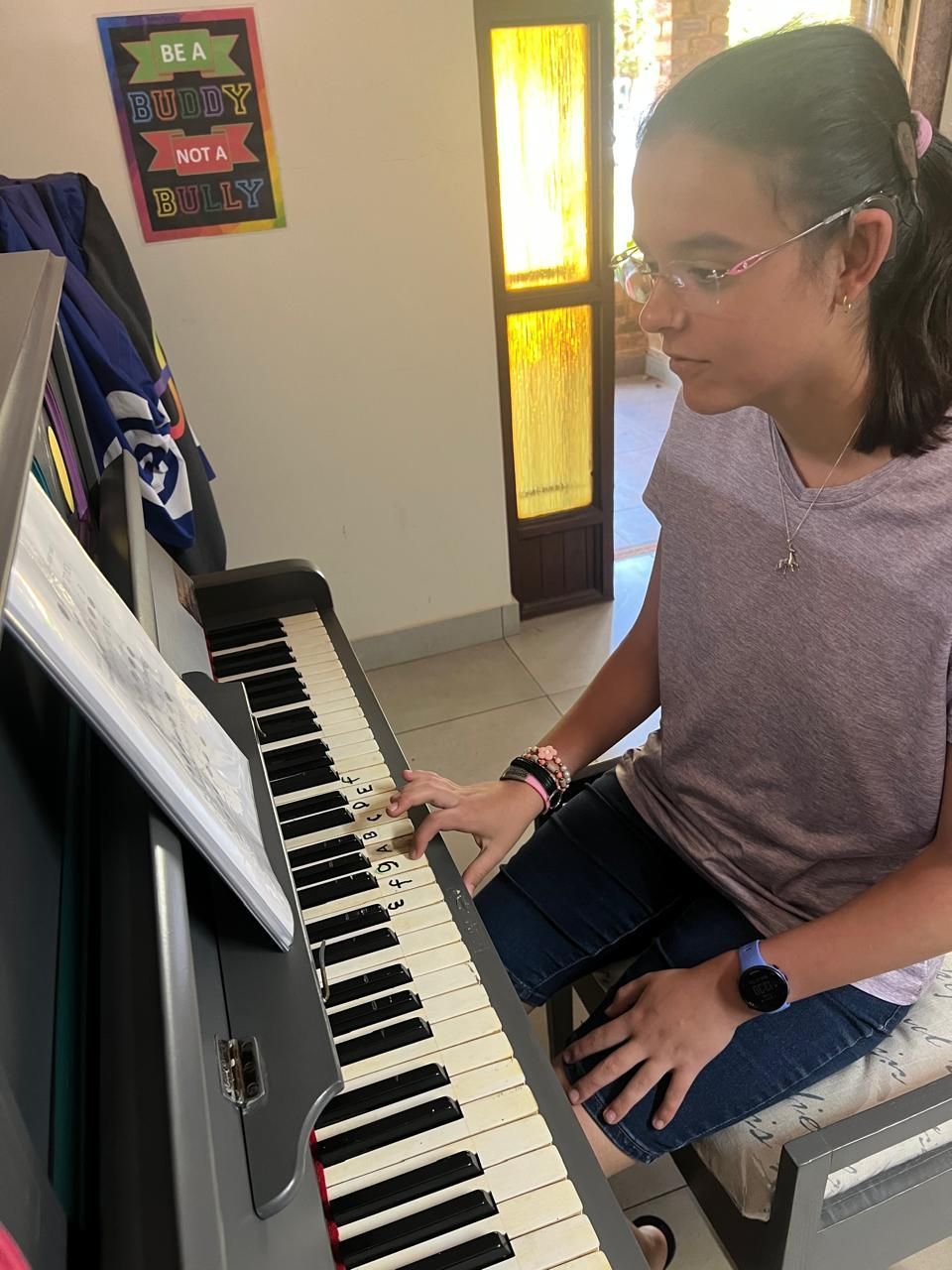 A young girl is playing a piano at Diverse Skills Academy.