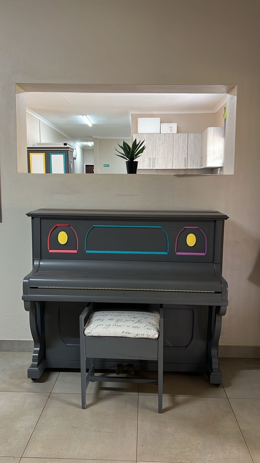 A piano is sitting in a room next to a window.