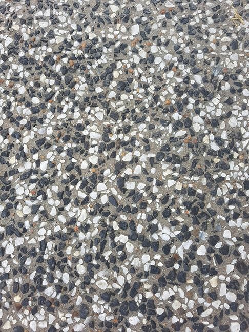 A Close Up Of A Concrete Surface With Black And White Gravel — B & C Donnachie Concrete Contractors in Mareeba, QLD