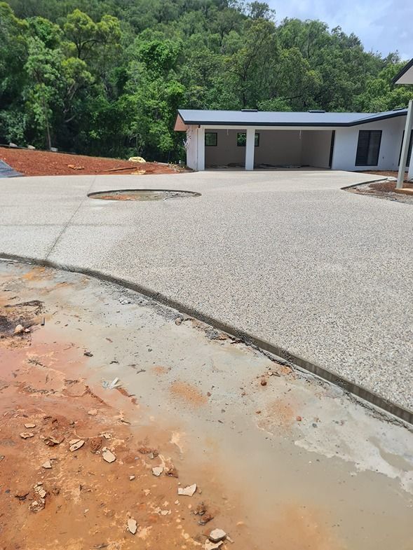 A Concrete Driveway Is Being Built In Front Of A House — B & C Donnachie Concrete Contractors in Atherton, QLD