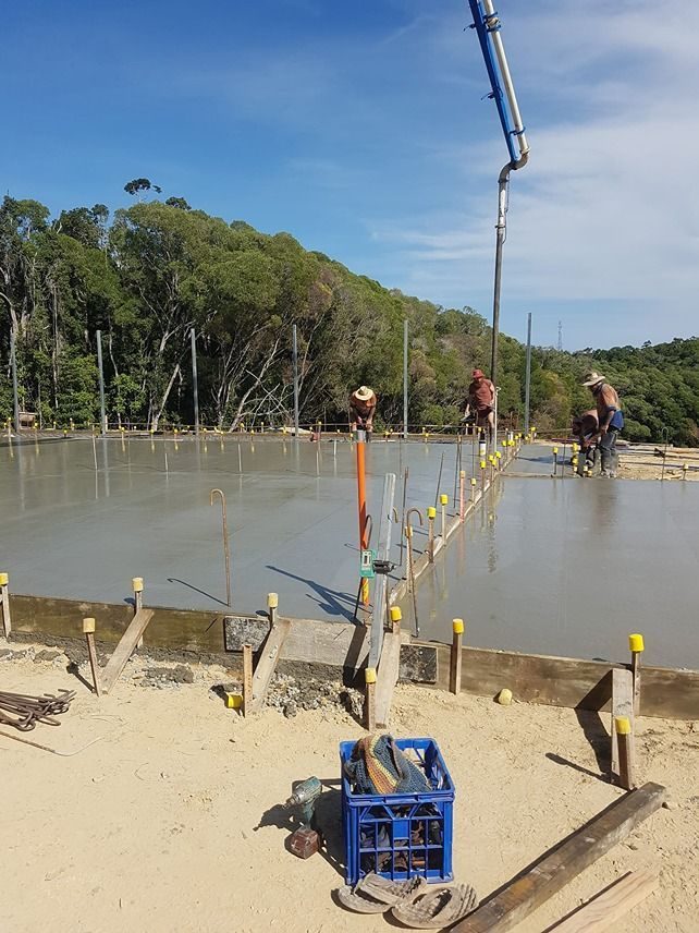 A Concrete Pump Is Being Used To Pour Concrete On A Construction Site — B & C Donnachie Concrete Contractors in Mareeba, QLD