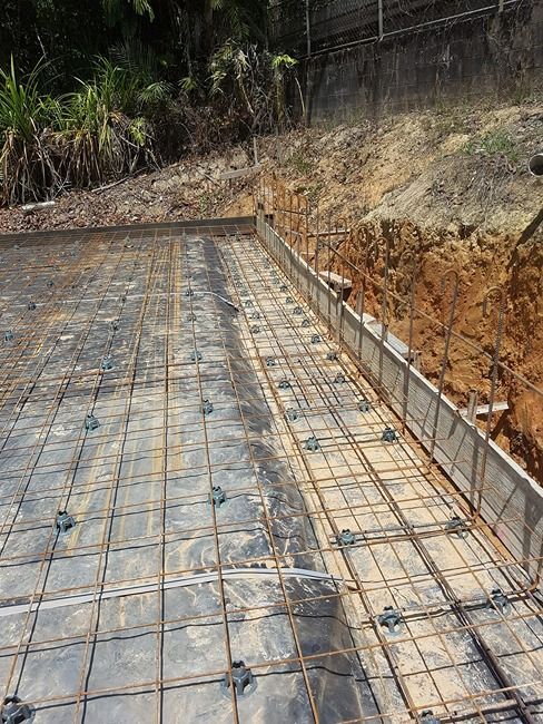 A Concrete Foundation Is Being Built In A Dirt Field — B & C Donnachie Concrete Contractors in Kuranda, QLD