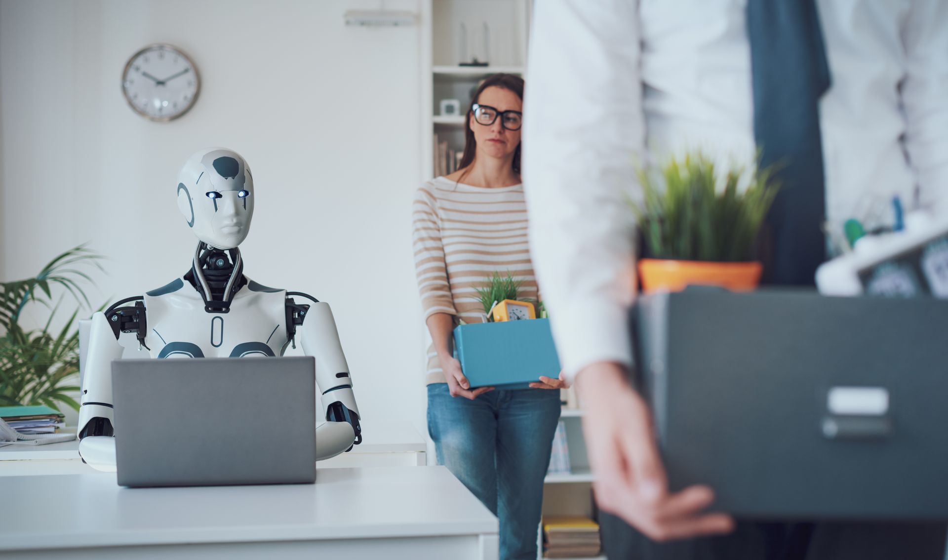 AI droids replacing workers carrying boxes of personal items out of an office.