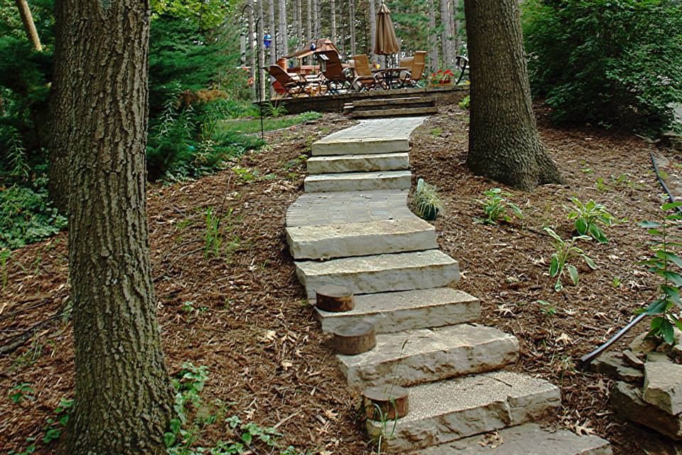 A Stone Walkway Leading To A Deck In The Woods — Menasha, WI — Artscapes COC