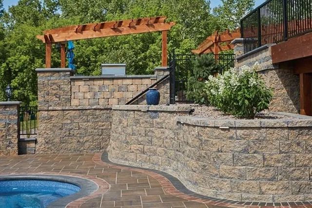 A Brick Wall Surrounds A Swimming Pool With A Pergola Over It — Menasha, WI — Artscapes COC