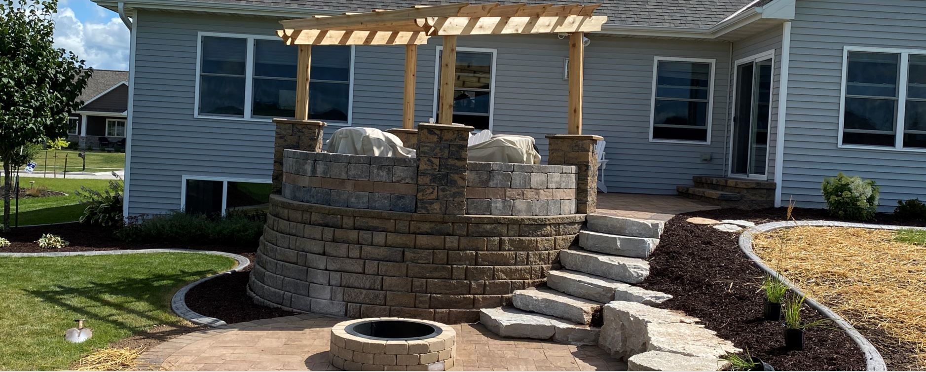 House With A Fire Pit And Stairs In Front Of It — Menasha, WI — Artscapes COC