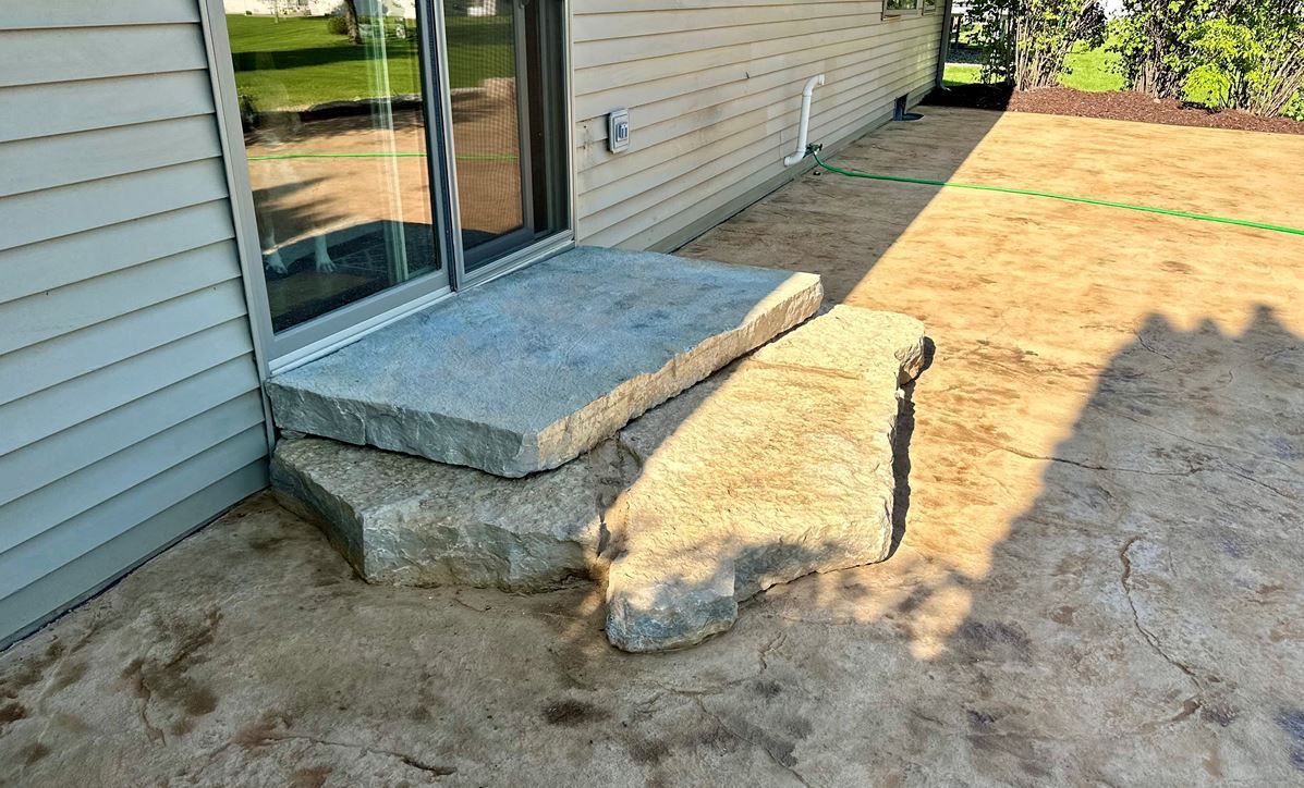 A stone step on a stamped concrete patio in Wisconsin