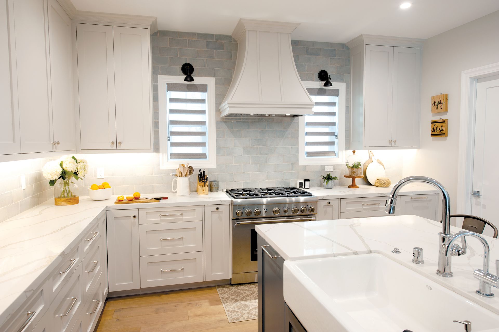 White kitchen with island, stainless steel appliances, and a tiled backsplash.
