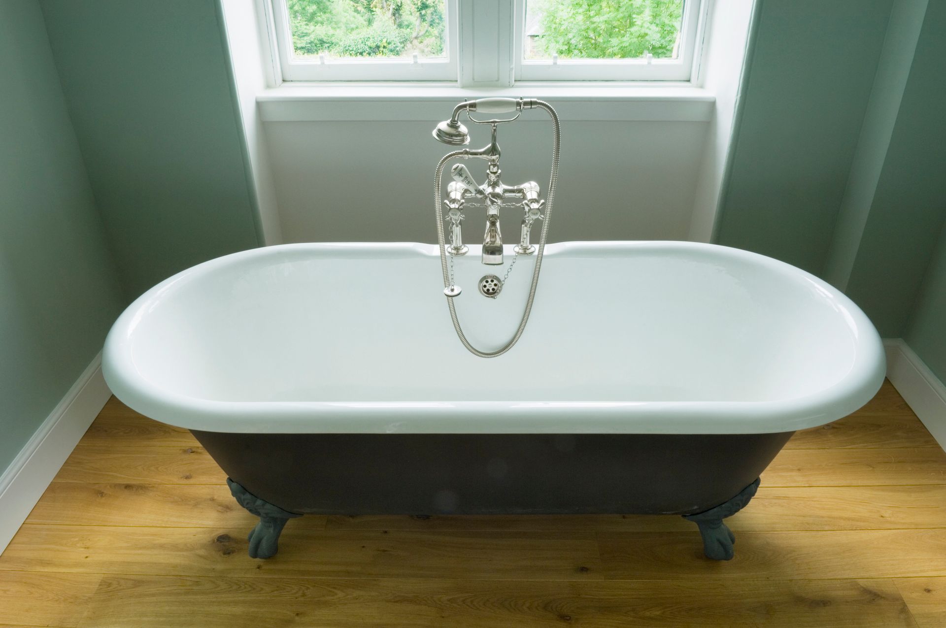 A bathtub is sitting in a bathroom next to a window.