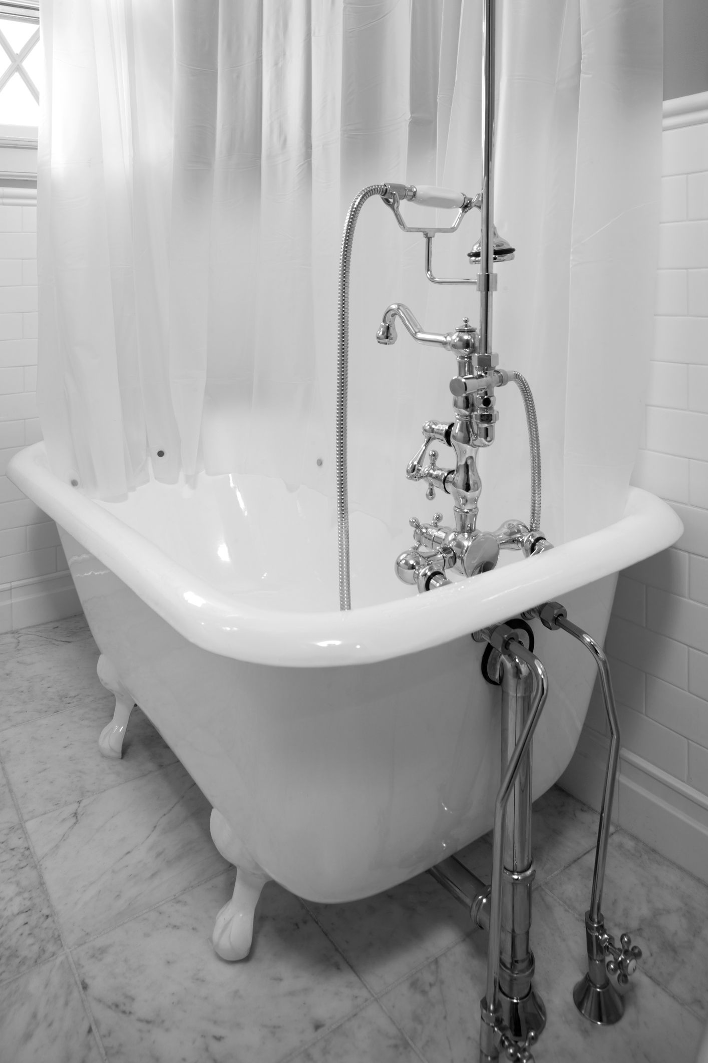 A black and white photo of a bathtub in a bathroom