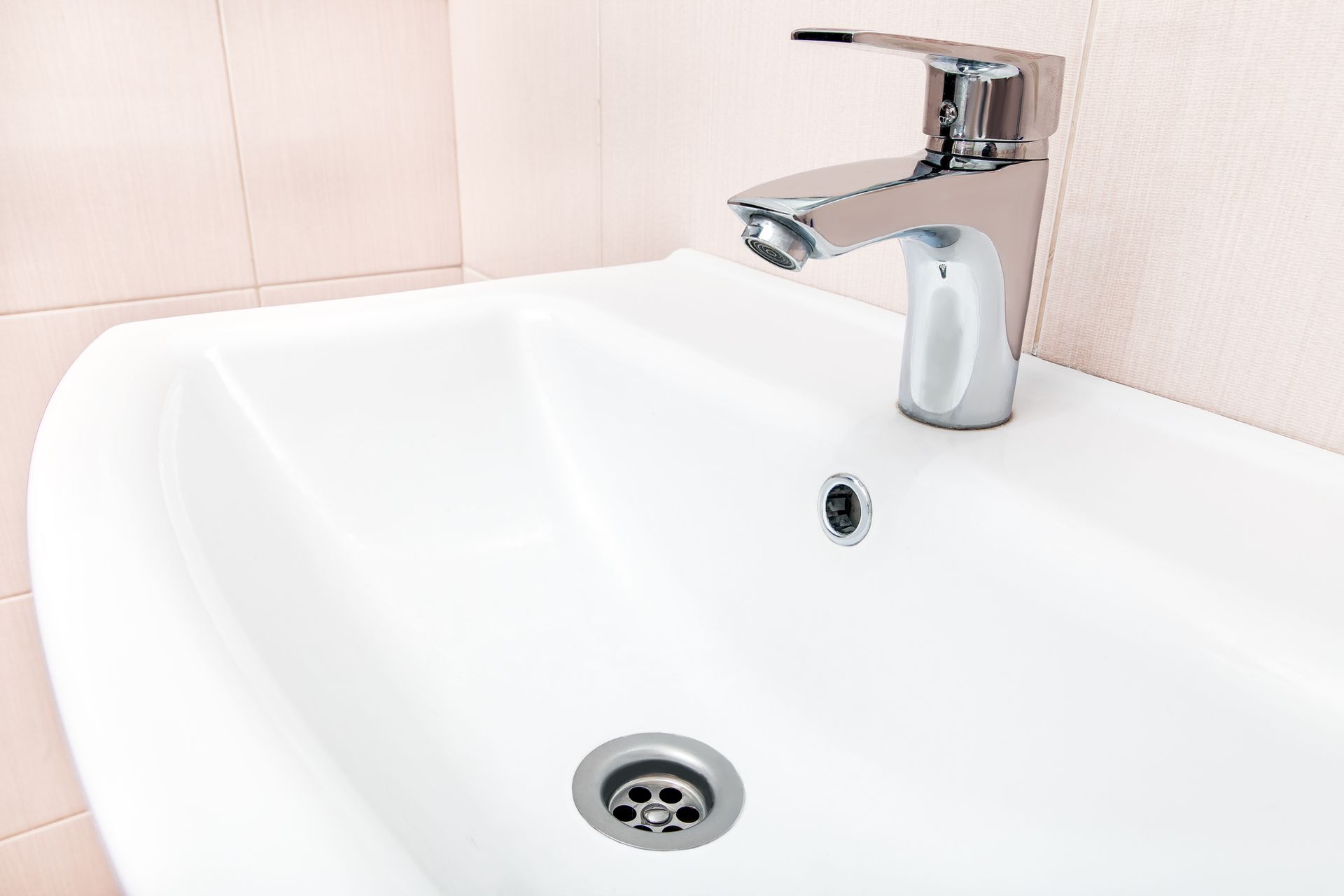 A bathroom sink with a chrome faucet and drain.