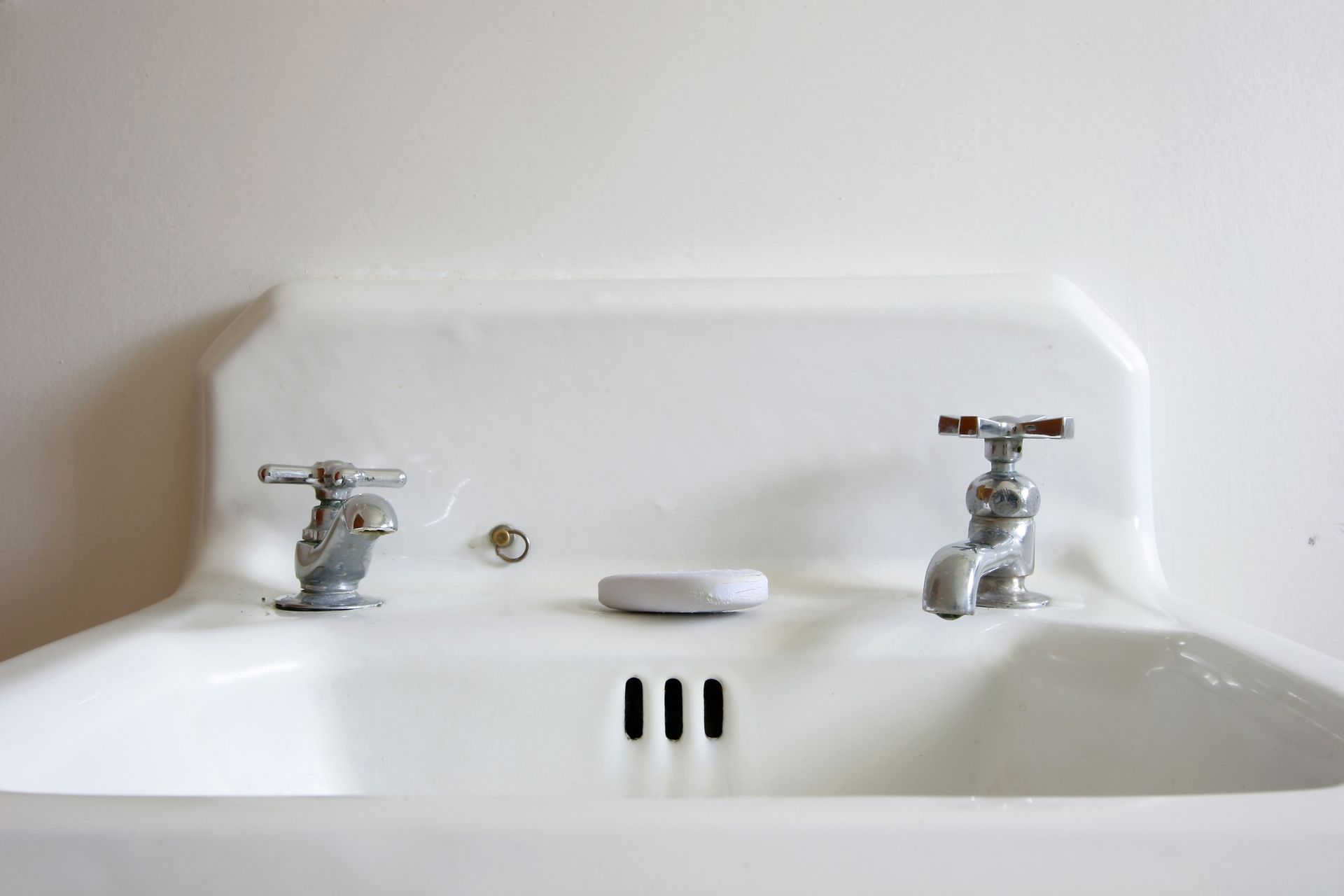 A bathroom sink with a marble counter top and chrome faucets.