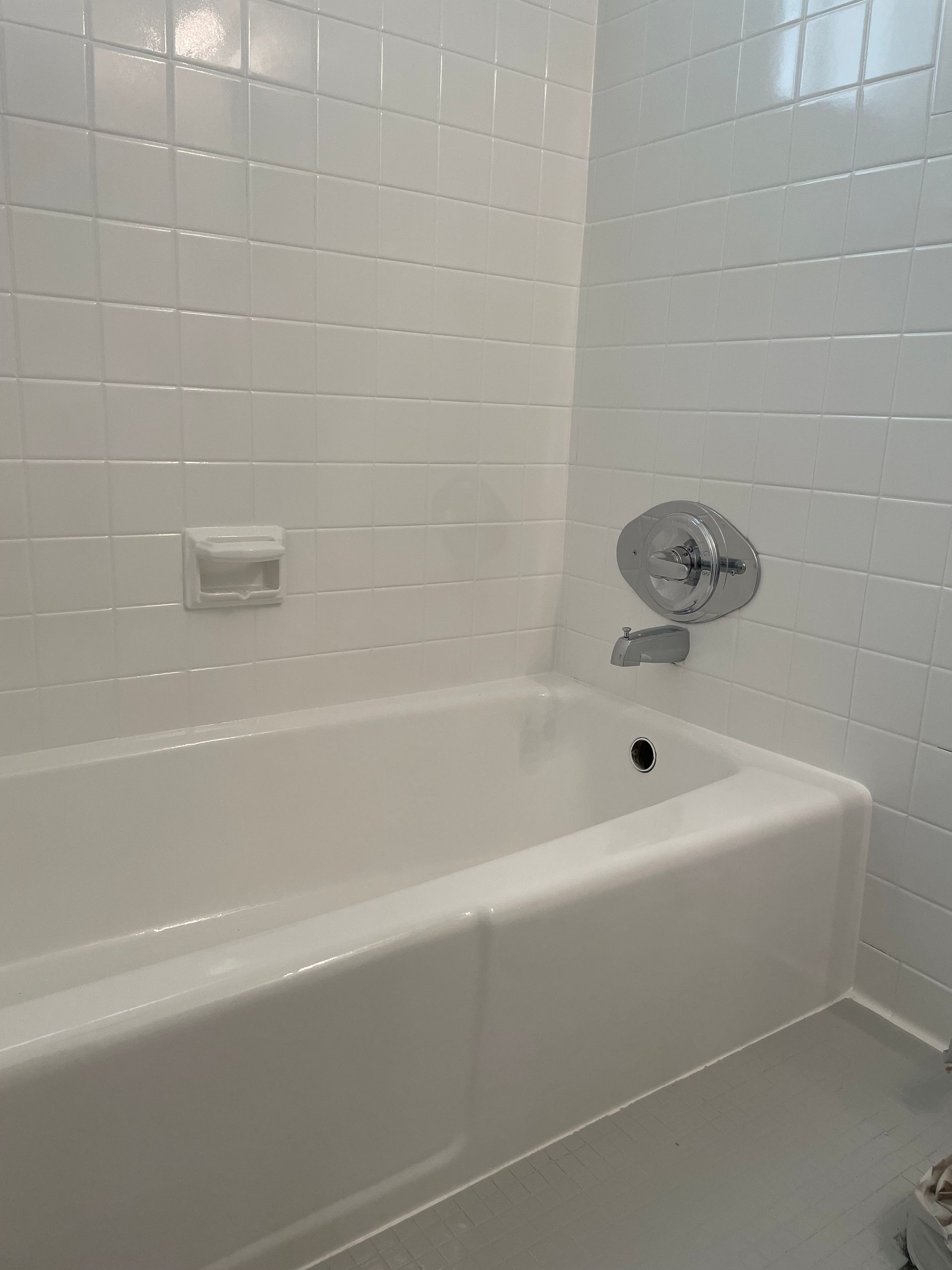 A bathroom with a bathtub , sink , and mirror.
