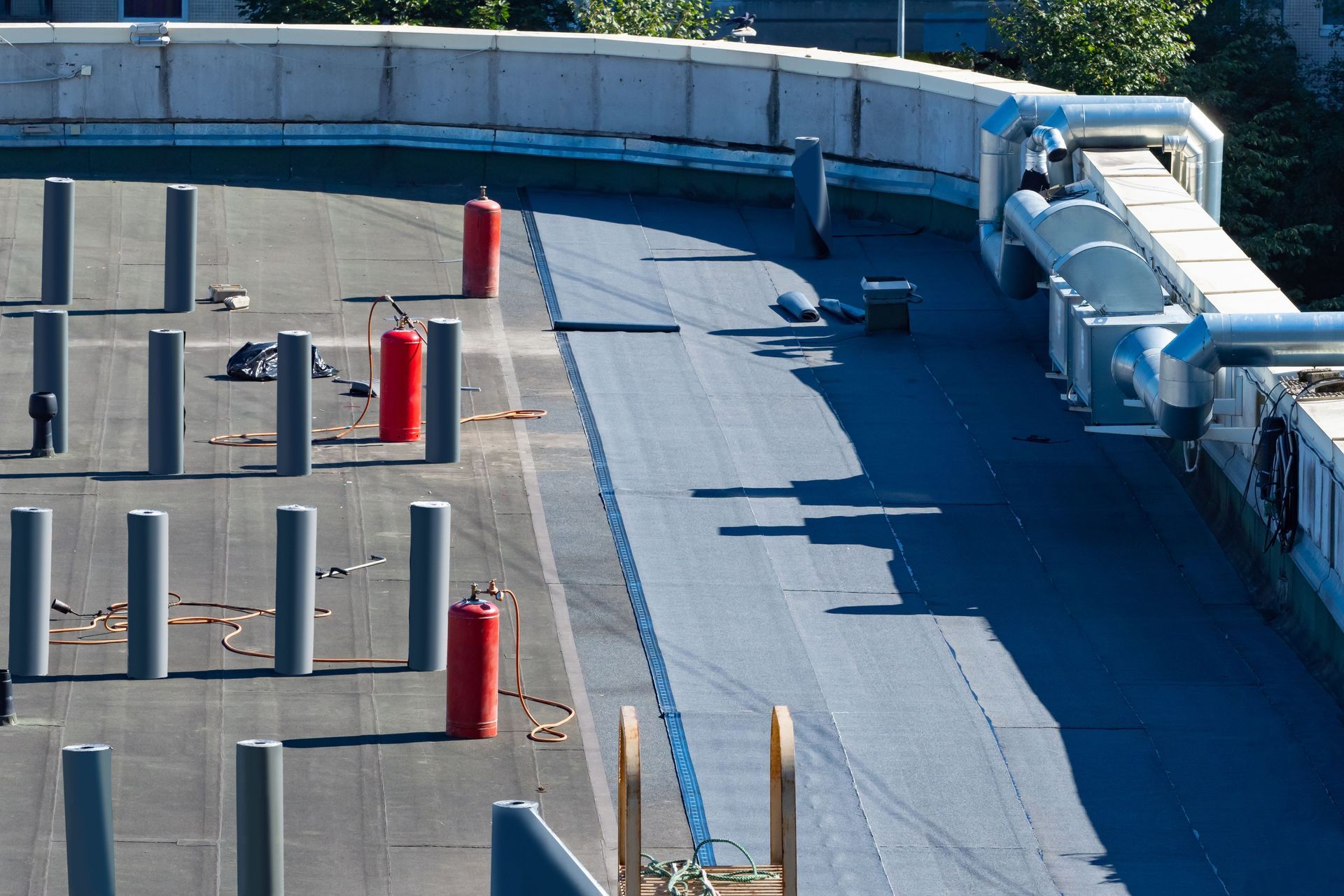 Flat rooftop with evenly spaced pillars, fire extinguishers, and ventilation ducts.