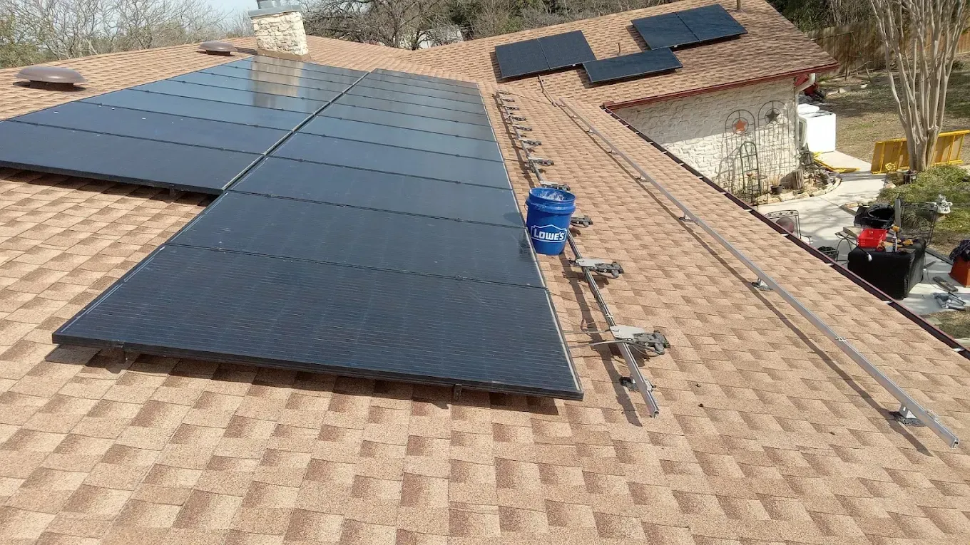 Solar panels installed on a brown shingle roof; construction in progress.