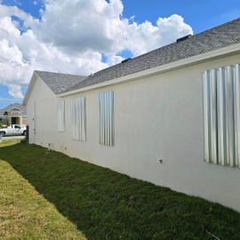 White residential house with accordion shutters.