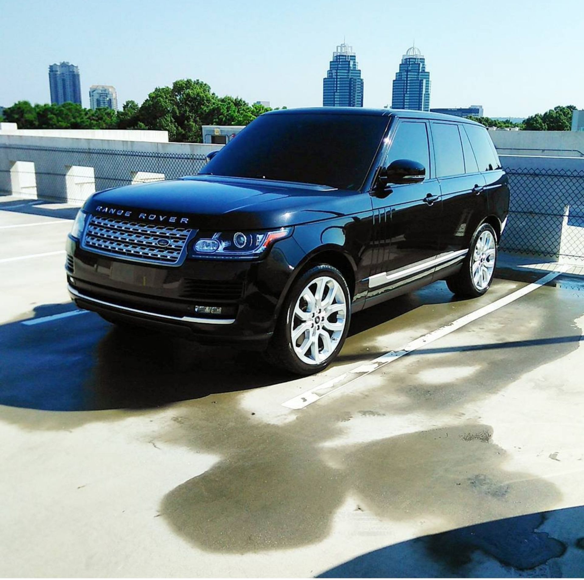 A black range rover is parked in a parking lot