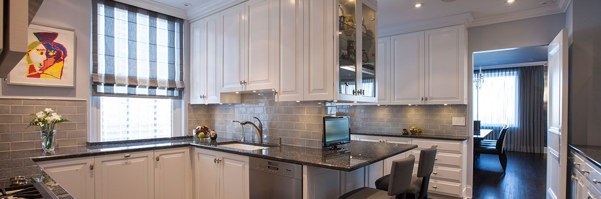 A kitchen with white cabinets and granite counter tops