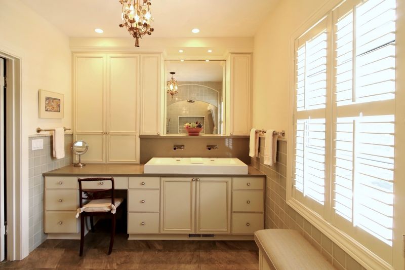 A bathroom with a sink , mirror and shutters
