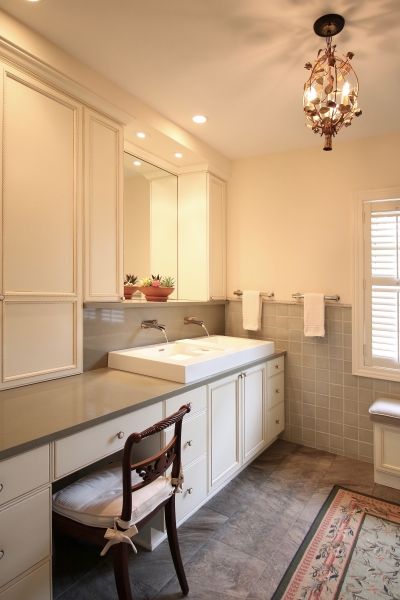 A bathroom with a sink a desk and a chair
