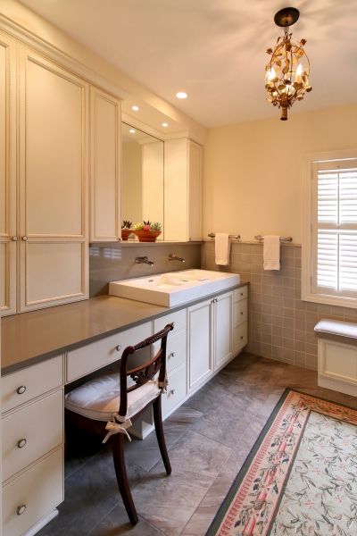 A bathroom with two sinks a desk and a chair