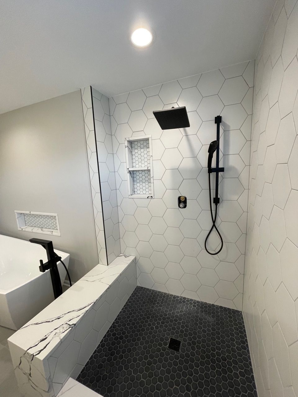 A bathroom with a walk in shower and a bathtub.