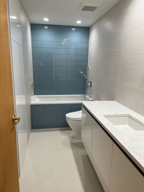 A bathroom with a toilet , sink and bathtub