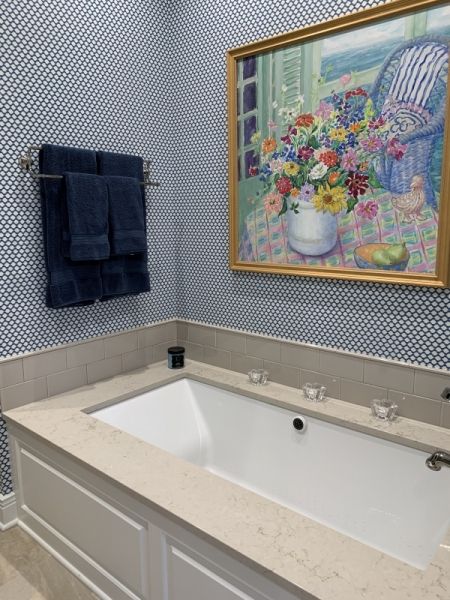 A bathroom with a bathtub and a painting on the wall above it
