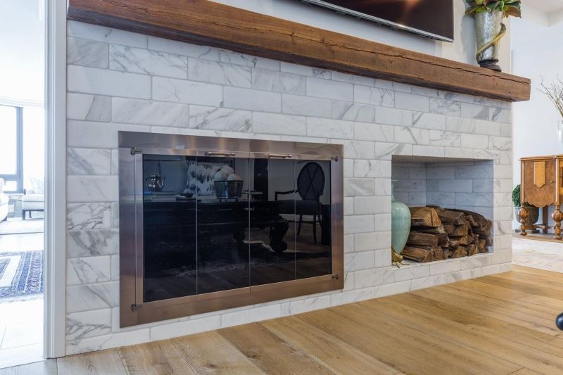 A living room with a fireplace and a television on the wall.