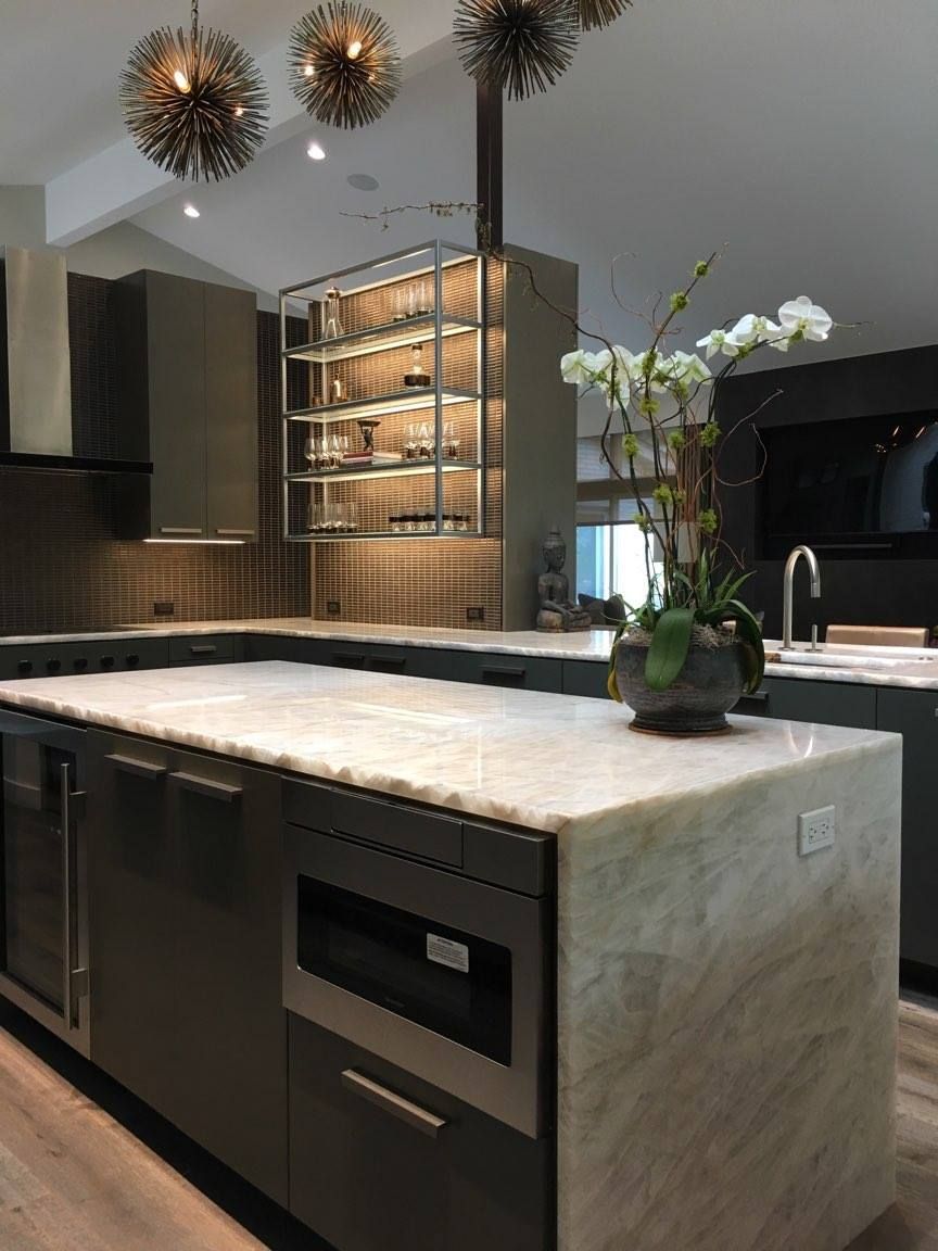 A kitchen with a large island and a vase of flowers on it