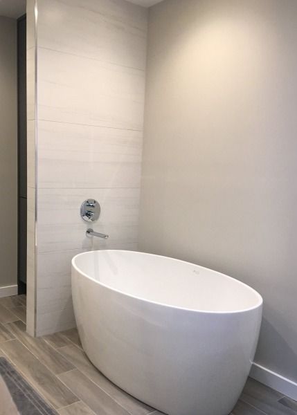 A white bathtub is sitting in a bathroom next to a shower.